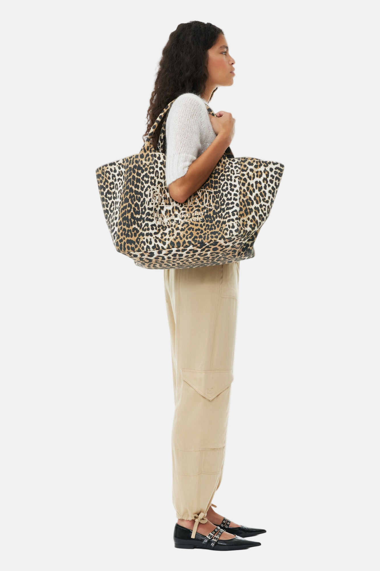 Model trägt den GANNI XXL Leopard Shopper mit großem Hauptfach und Logo-Print.
