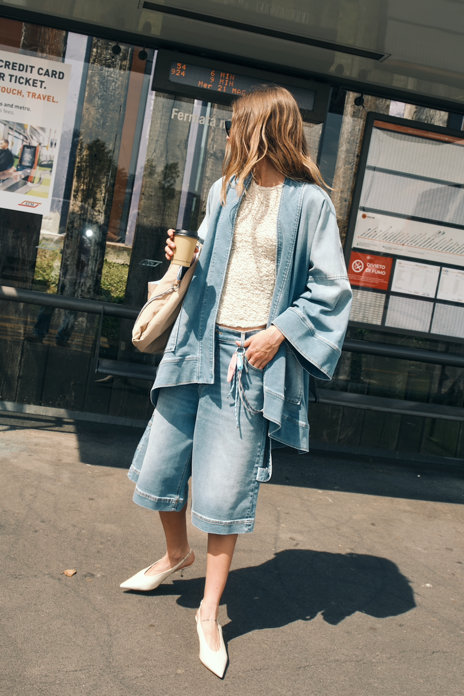 Model kombiniert die 8PM Cancun Denim Shorts mit Denim-Kimono und cremefarbenem Top für einen modernen Sommer-Look.