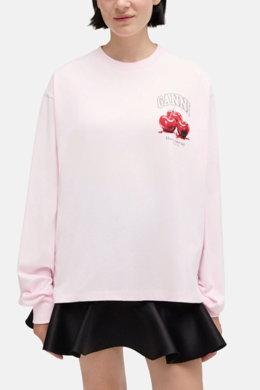 Model trägt das GANNI Washed Effect Cotton Jersey Longsleeve in Chalk Pink, Cherry Print, bequeme Passform.
